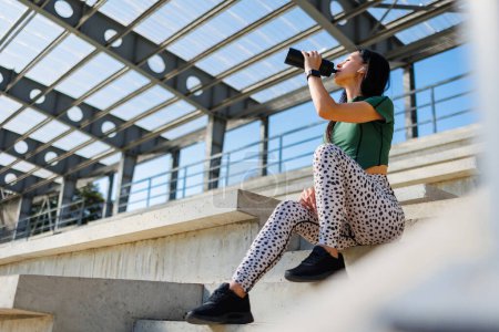 Foto de Mujer joven activa con botella de agua al aire libre - Imagen libre de derechos