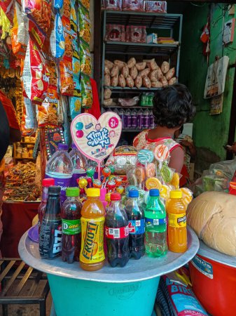 Foto de Tulajapur, India- 28 de octubre de 2022; Foto de stock de diferentes tipos de refrescos, bebidas frías, dulces, piruletas y botellas de agua que se mantienen en la mesa fuera de la tienda.Foto capturada en el área del mercado de la India - Imagen libre de derechos