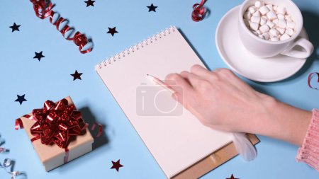 Foto de Chica o mujer escribiendo una carta a Santa Claus y bebiendo cacao. Año nuevo o Navidad concepto de vídeo de vacaciones. Resolución 4K - Imagen libre de derechos