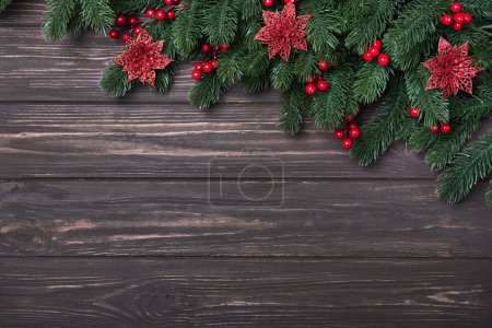 Photo for Classic Christmas composition with fir branches, poinsettia and holly berries on a wooden backdrop. Happy Holidays concept. Flat lay, Copy space, Mock up - Royalty Free Image