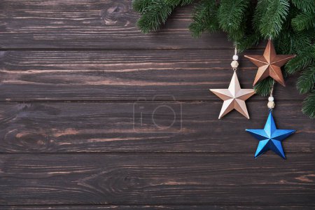 Photo for Winter background with fir branches and Christmas decorations in form of star on a wooden backdrop. Happy Holidays concept in minimalistic style. Flat lay, Copy space, Mock up - Royalty Free Image