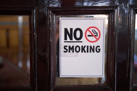 No Smoking sign displayed on a vintage wooden door, health-conscious setting
