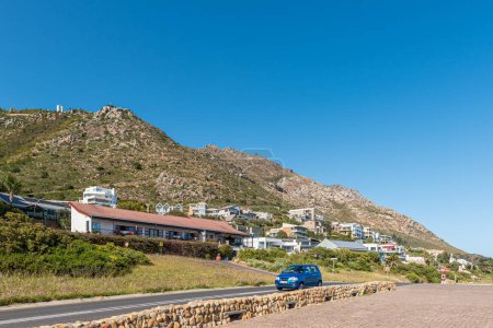 Téléchargez les photos : Gordons Bay, Afrique du Sud - 20 sept. 2022 : Scène de rue sur la route R64 à Gordons Bay dans la province du Cap occidental. Maisons de luxe et une voiture sont visibles - en image libre de droit