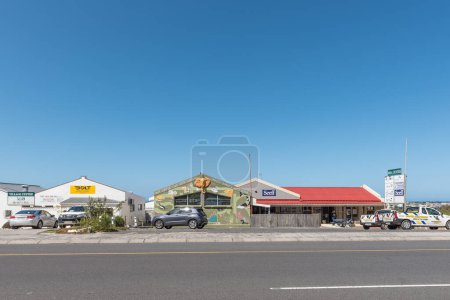 Foto de Bettys Bay, Sudáfrica - 20-sep-2022: Una escena callejera, con negocios, personas y vehículos, en Bettys Bay en la Provincia Occidental del Cabo - Imagen libre de derechos