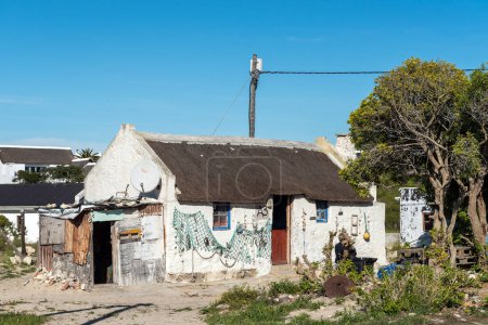 Téléchargez les photos : Arniston, Afrique du Sud - 22 sept. 2022 : Une scène de rue, avec maison historique, à Kassiesbaai, un village de pêcheurs historique à Arniston dans la province du Cap occidental - en image libre de droit