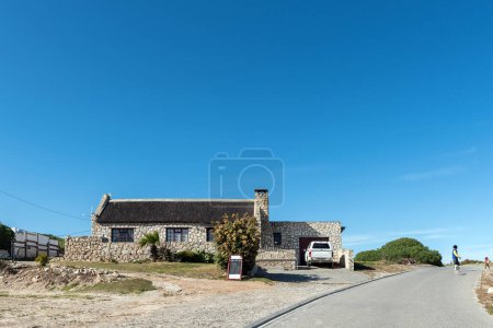 Photo for Arniston, South Africa - Sep 22, 2022: A street scene, with Miens Tea Garden, in Kassiesbaai, Arniston in the Western Cape Province. People and a vehicle are visible - Royalty Free Image