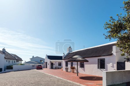 Téléchargez les photos : Arniston, Afrique du Sud - 22 sept. 2022 : Une scène de rue, avec le bureau d'accueil de Arniston Seaside Cottages, à Arniston dans la province du Cap occidental - en image libre de droit
