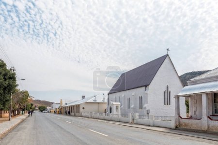 Téléchargez les photos : VICTORIA WEST, SOUTH AFRICA - SEP 2, 2022:  A street scene, with historic houses, St. Johns Anglican Church, businesses and people, in Victoria West in the Northern Cape Province - en image libre de droit