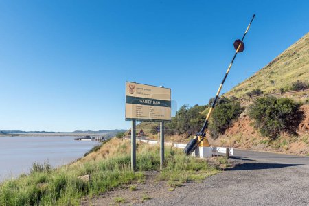 Photo for Gariepdam, South Africa - Feb 21, 2023: Information board and boom at the start of the road to the wall of the Gariep Dam. The dam is overflowing - Royalty Free Image