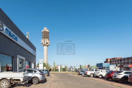 Téléchargez les photos : Kimberley, Afrique du Sud - 24 février 2023 : Une scène de rue, avec des véhicules et des entreprises visibles, à Kimberley. La tour de télécommunications micro-ondes est visible - en image libre de droit