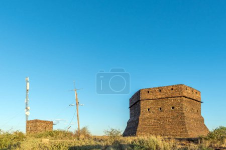 Téléchargez les photos : Un blockhaus sur une colline gardait Prieska pendant la Seconde Guerre des Boers. Il a été construit à partir de pierres oculaires de tigres semi-précieuses. Une tour de télécommunications est visible - en image libre de droit