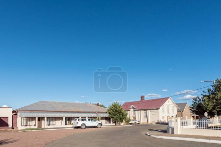 Foto de Prieska, Sudáfrica - 28 feb 2023: Una escena callejera, con una casa adosada y el vestíbulo de la Iglesia Reformada Holandesa, en Prieska, en la Provincia del Cabo Norte - Imagen libre de derechos