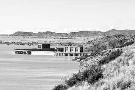 Photo for Gariepdam, South Africa - Feb 21, 2022: The largest dam in South Africa, the Gariep Dam, overflowing. It is in the Orange River. People and vehicles are visible. Monochrome - Royalty Free Image
