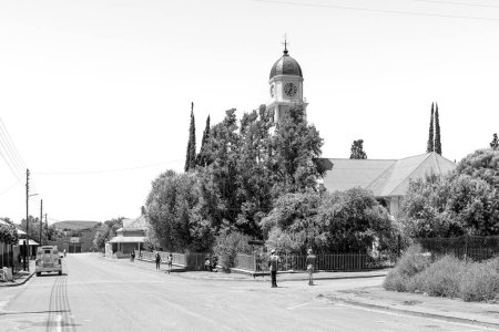 Foto de Petrusville, Sudáfrica - 21 de febrero de 2022: Una escena callejera, con la Iglesia Reformada Holandesa y el pueblo, en Petrusville, en la Provincia del Cabo Norte. Monocromo - Imagen libre de derechos
