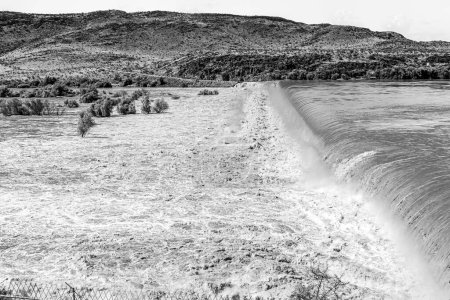 Photo for The wall of the Boegoeberg Dam is completely covered by the flooded Orange River. Monochrome - Royalty Free Image