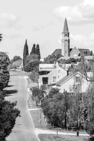 Foto de Stanford, Sudáfrica - 20 de septiembre de 2022: Una escena callejera en Stanford, en la Provincia Occidental del Cabo. La iglesia reformada holandesa es visible. Monocromo - Imagen libre de derechos