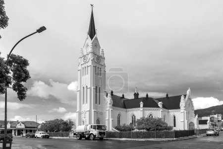 Foto de Bredasdorp, Sudáfrica - 23 de septiembre de 2022: Una escena callejera, con la Iglesia Reformada Holandesa, en Bredasdorp, en la Provincia Occidental del Cabo. Los vehículos son visibles. Monocromo - Imagen libre de derechos