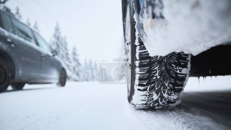Nahaufnahme der Reifen des Autos auf schneebedeckter und vereister Straße. Themen Sicherheit und Autofahren im Winter