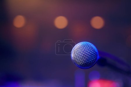 Foto de Primer plano del micrófono iluminado en el escenario contra proyectores - Imagen libre de derechos