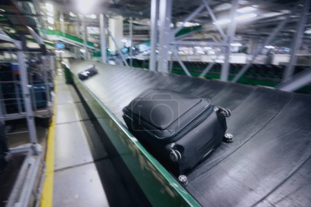 Foto de Traveling by airplane. Luggage on conveyor belt in blurred motion. Baggage sorting at airport. - Imagen libre de derechos