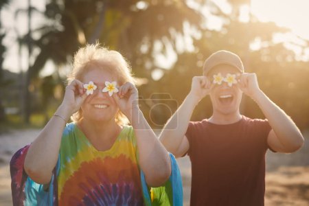 Téléchargez les photos : Drôle de portrait de la femme âgée heureuse avec son fils adulte pendant le voyage dans la destination tropicale - en image libre de droit