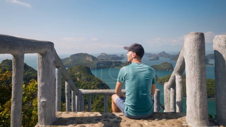 Téléchargez les photos : Homme assis sur l'escalier sur la colline et regardant la mer avec groupe belles îles tropicales. Parc marin national Ang Thong près de Koh Samui en Thaïlande - en image libre de droit