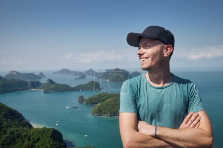 Téléchargez les photos : Portrait d'homme riant sur une colline contre un groupe d'îles tropicales en mer, Thaïlande - en image libre de droit