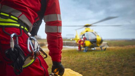 Photo for Selective focus on safety harness of paramedic of emergency service in front of helicopter. Themes rescue, help and hope - Royalty Free Image