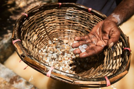 Téléchargez les photos : Travailleur montrant des pierres précieuses trouvées dans la mine Moonstone au Sri Lanka. Ces pierres précieuses sont ensuite traitées pour la fabrication de bijoux - en image libre de droit
