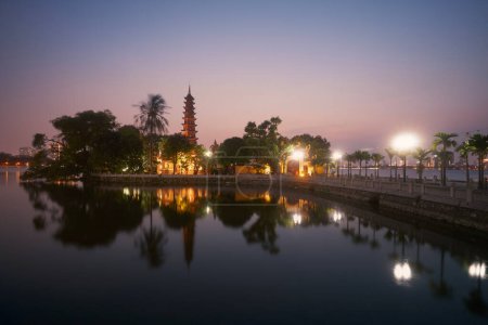 Téléchargez les photos : Lac ouest et reflet de l'eau de la pagode Tran Quoc illuminée - le plus ancien temple bouddhiste de Hanoi au crépuscule, Vietnam - en image libre de droit