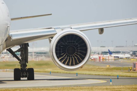 Photo for Hot air behind jet engine of plane at airport. Airplane is taxiing to runway for take off during sunny summer day - Royalty Free Image
