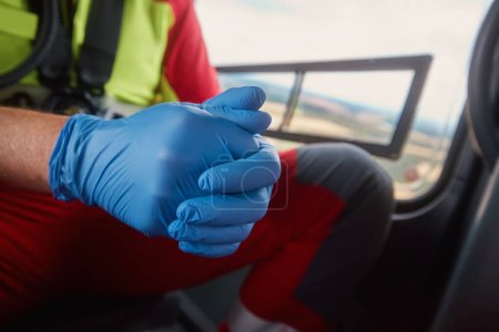 Photo for Close-up hands of doctor in surgical gloves inside helicopter of emergency medical service. Themes rescue, help and hope - Royalty Free Image