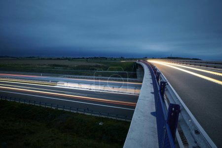 Photo for Road overpass over multiple lane highway in countryside at twilight. Themes car transportation, direction and connection - Royalty Free Image