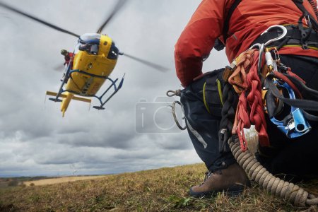 Photo for Selective focus on safety harness of paramedic of emergency service in front of landing helicopter. Themes rescue, teamwork and hope - Royalty Free Image