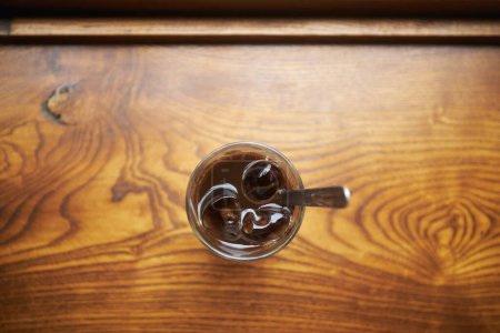 Photo for Close-up of glass of Vietnamese iced coffee on wooden table. Selective focus on ice cubes. Still life with coffee in Hanoi in Vietnam - Royalty Free Image