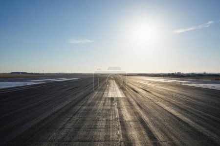 Foto de Nivel de superficie de la pista de aterrizaje del aeropuerto largo con marcado direccional contra el cielo despejado. - Imagen libre de derechos