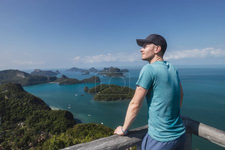 Téléchargez les photos : L'homme heureux profite d'une vue imprenable depuis le sommet de la colline. Groupe d'îles tropicales en mer près de Koh Samui en Thaïlande - en image libre de droit