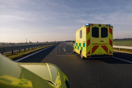 Photo for Two fast moving ambulance cars of emergency medical service on highway. Themes health care, rescue and urgency - Royalty Free Image