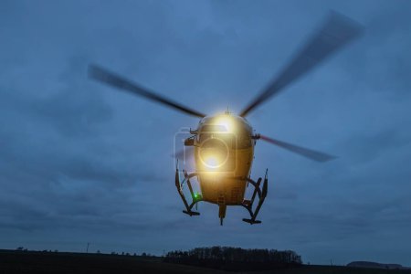 Foto de Helicóptero del servicio médico de emergencia durante el despegue por la noche. Temas de rescate, ayuda y esperanza - Imagen libre de derechos