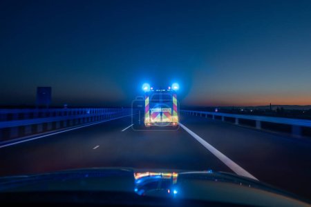 Photo for Fast moving ambulance car of emergency medical service on highway at night. Themes health care, rescue and urgency - Royalty Free Image