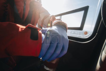 Close-up hands of prepared doctor in surgical gloves inside helicopter of emergency medical service. Themes rescue, help and hope
