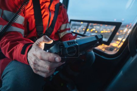 Close-up of hands of doctor inside helicopter emergency medical service while using digital tablet during a night mission flight