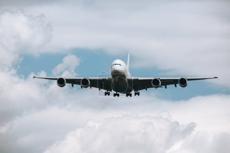 Téléchargez les photos : D'énormes avions volent à travers les nuages. Avion approchant lors de l'atterrissage à l'aéroport par temps ensoleillé - en image libre de droit