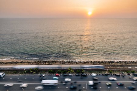 Téléchargez les photos : Route et voie ferrée le long de la côte au coucher du soleil sur l'océan Indien. Arrivée du train à Colombo, Sri Lanka - en image libre de droit