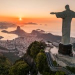 Rio de Janeiro, Brazil - March 21, 2023: Christ the Redeemer statue on top of the Corcovado Mountain with the Sugarloaf Mountain in the  horizon on sunrise.
