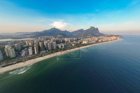 Luftaufnahme vom Strand Barra da Tijuca mit Eigentumswohnungen und Bergen am Horizont in Rio de Janeiro, Brasilien