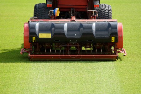 Foto de Tractor con aireador durante la aireación de un campo de fútbol - Imagen libre de derechos