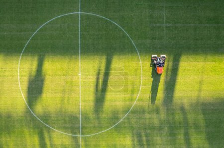 Photo for Drone view of the man moving grass at the football filed - Royalty Free Image