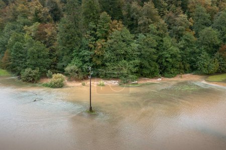 Foto de Inundación repentina de un arroyo de montaña o río que corre rápidamente desde el bosque y el área de campo circundante desbordante, vista aérea. - Imagen libre de derechos