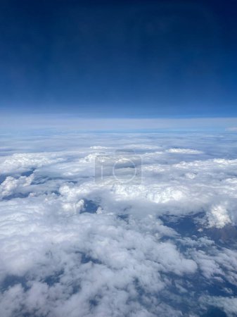 Photo for Stunning view of the expanse of land and sky, shot from thousand feet above the ground among white clouds. Smartphone photography - Royalty Free Image
